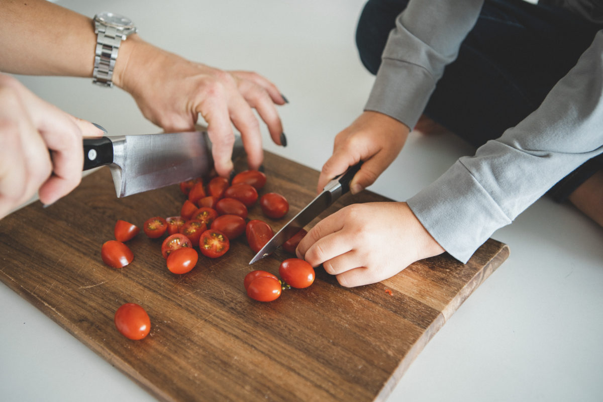 Hands cutting cherry tomatoes