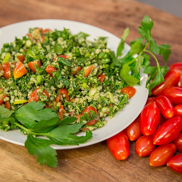 A plate of quinoa with a side of tomatoes.
