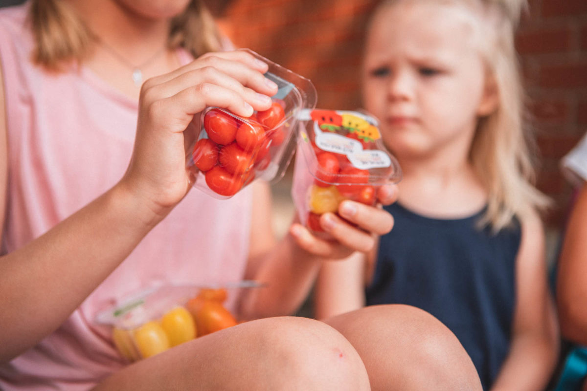 Girl holding snacking tomatoes pack