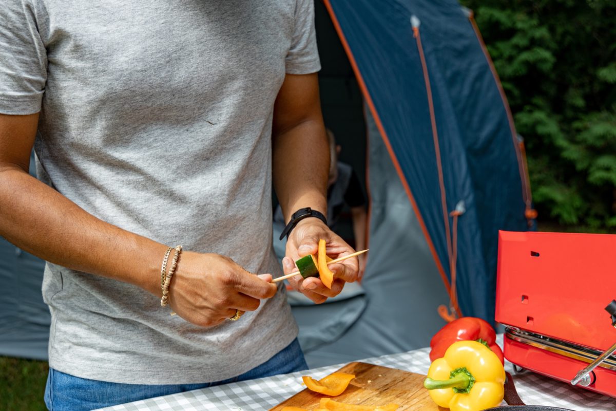 Hands cutting bell peppers in camping spot