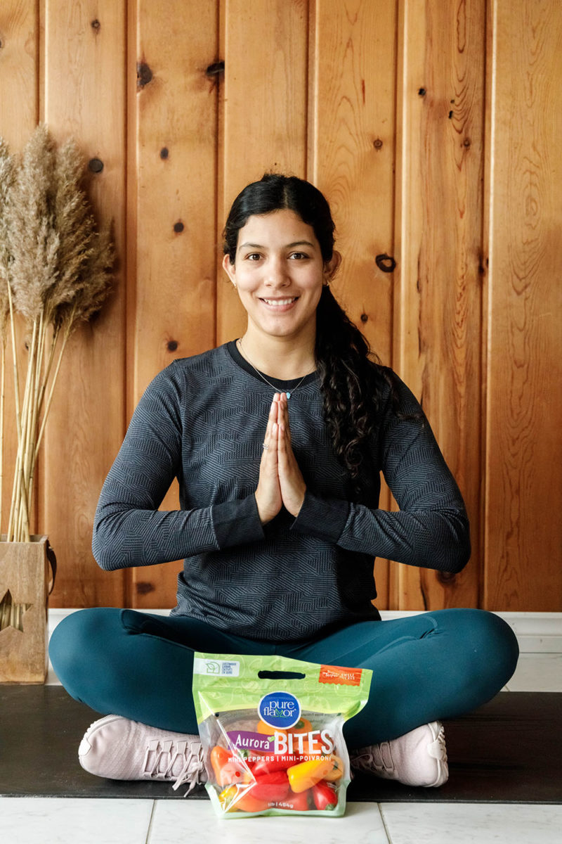 Woman seated in yoga pose with snacks.