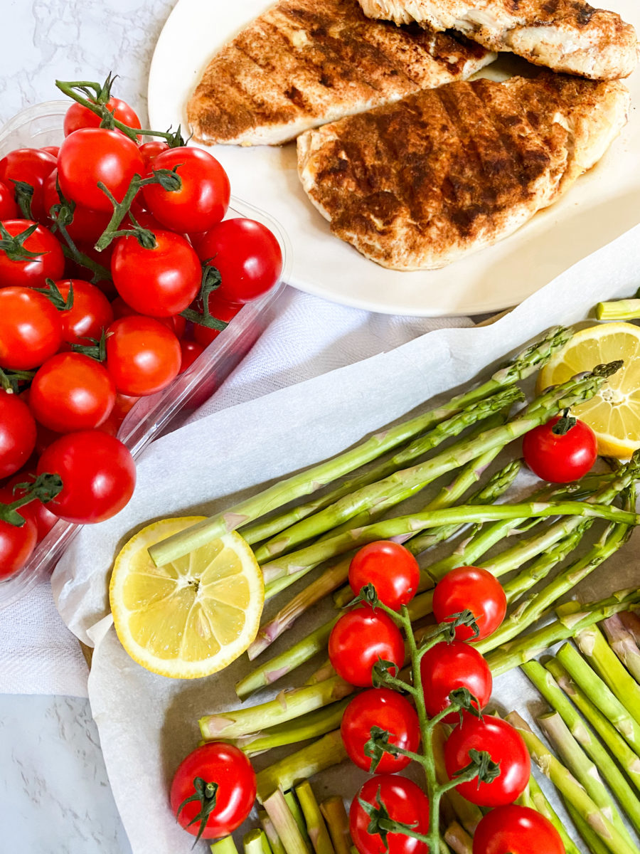 Plate with grilled chicken, asparagus and tomatoes