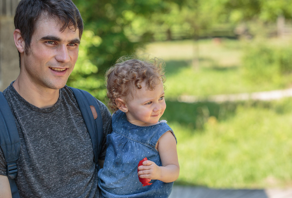 Father and toddler daughter enjoying a walk on some trails while snacking on mini sweet peppers.