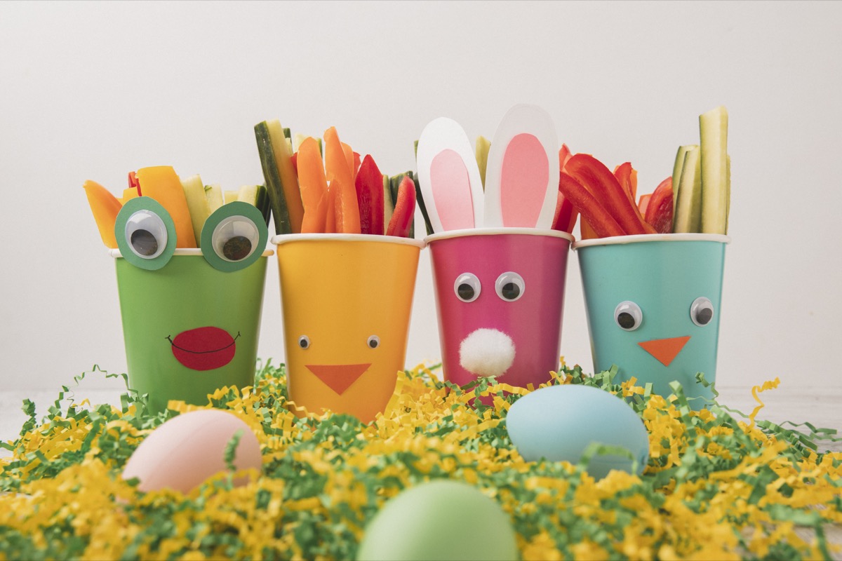 Multicolored easter plastic cups filled with fresh veggies.