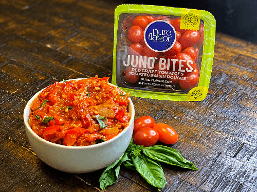 a bowl of tomato chutney with a pack of Juno Bites tomatoes