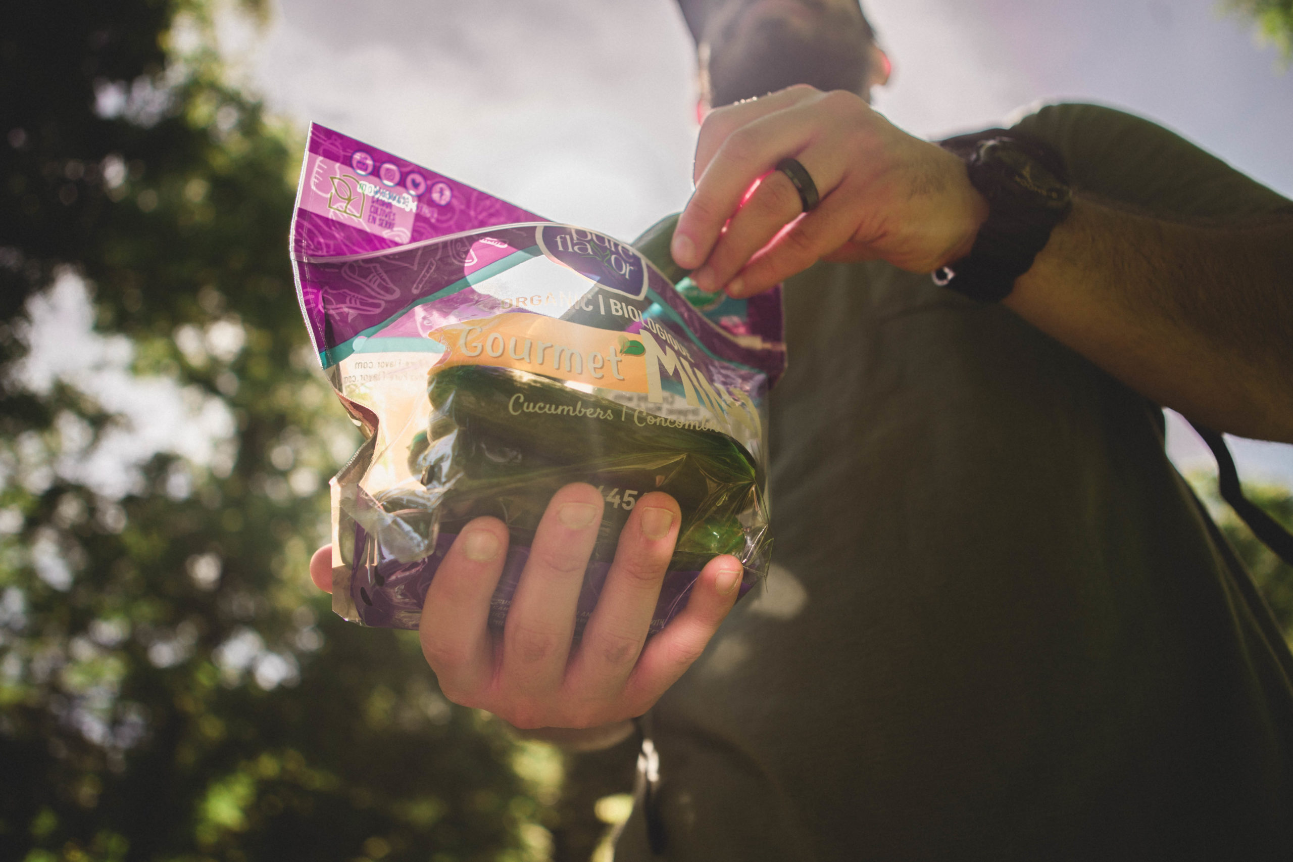 Man holding bag of Organic Mini Cucumbers