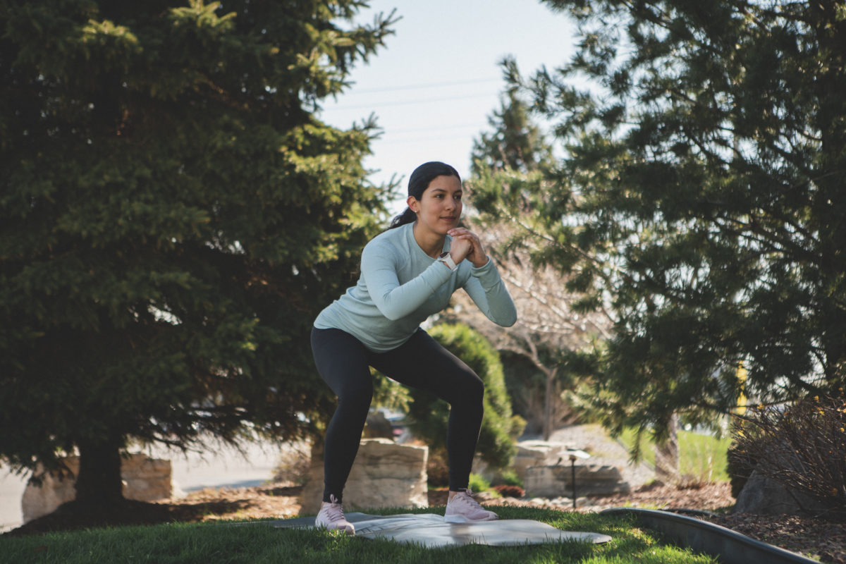 woman doing a squat in park