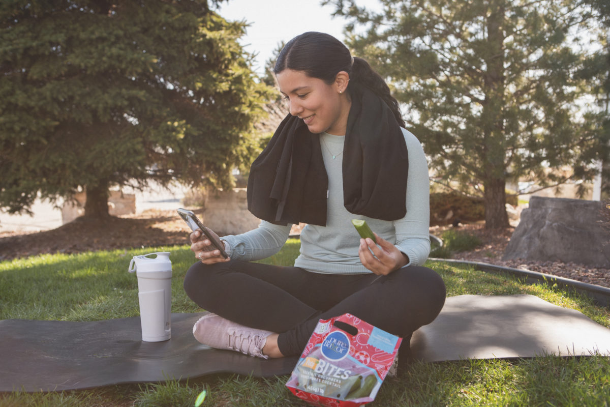 Woman seated eating post workout snack in park