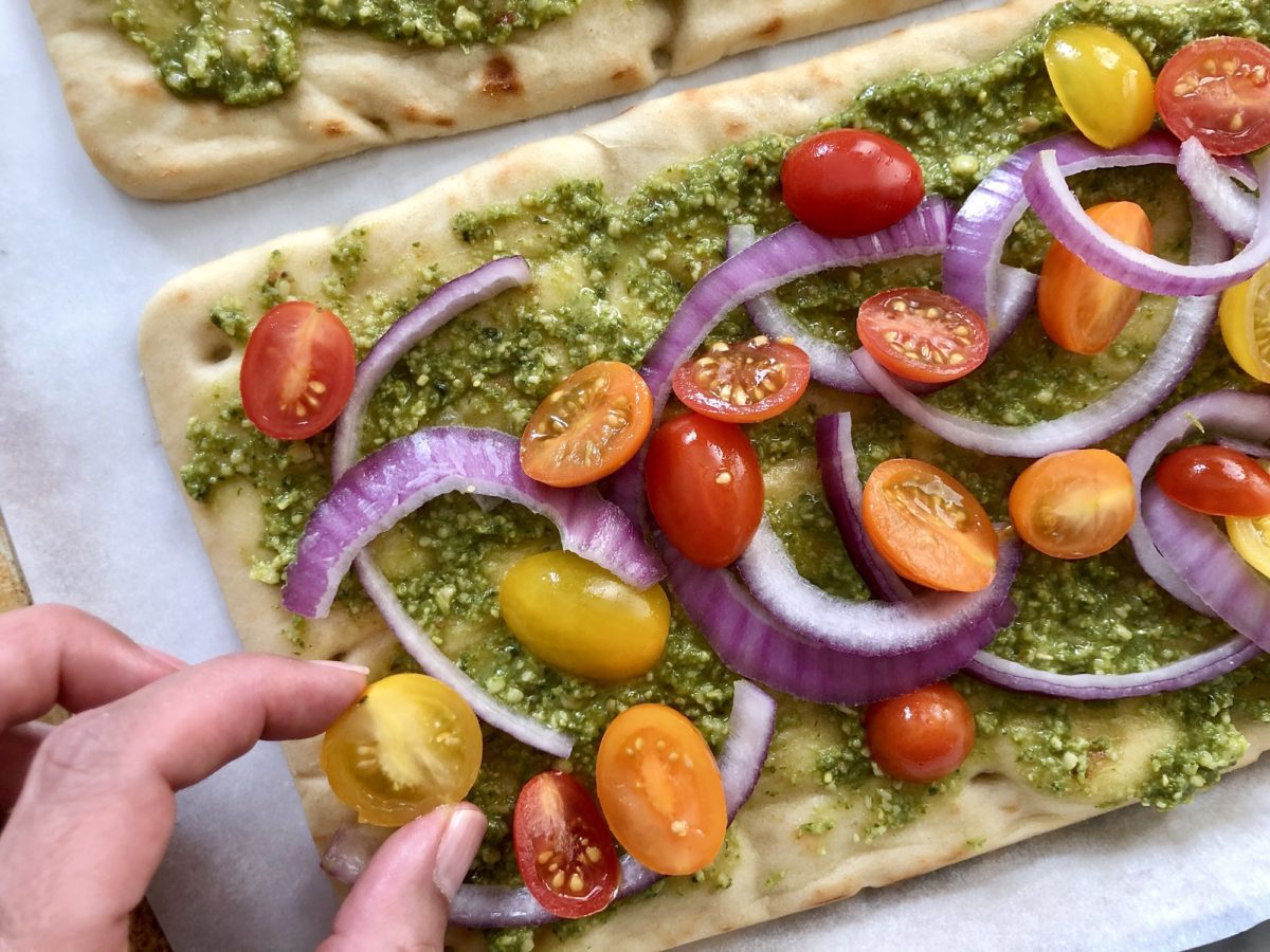 placing tomatoes on flatbread