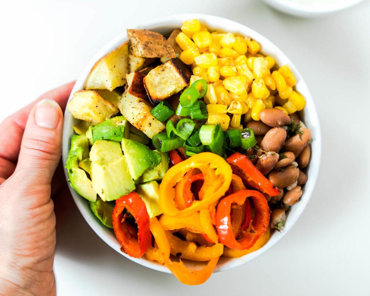 Close up of mexican buddha bowl with hand